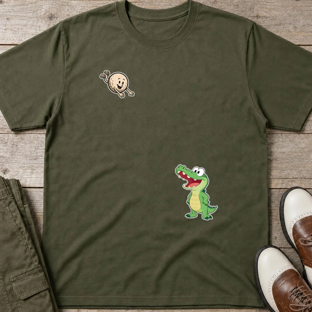 Flying Golf Croc T-Shirt in Military Green lying on a plain floor. T-shirt is a unisex cut and 100 per cent cotton.