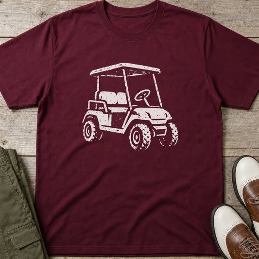Vintage Golf Cart T-Shirt in Maroon lying on a plain floor. T-shirt is a unisex cut and 100 per cent cotton.