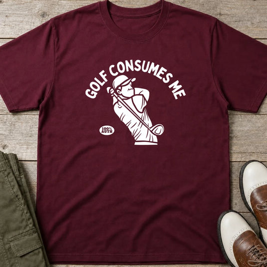 Golf Consumes Me T-Shirt in Maroon lying on a plain floor. T-shirt is a unisex cut and 100 per cent cotton.