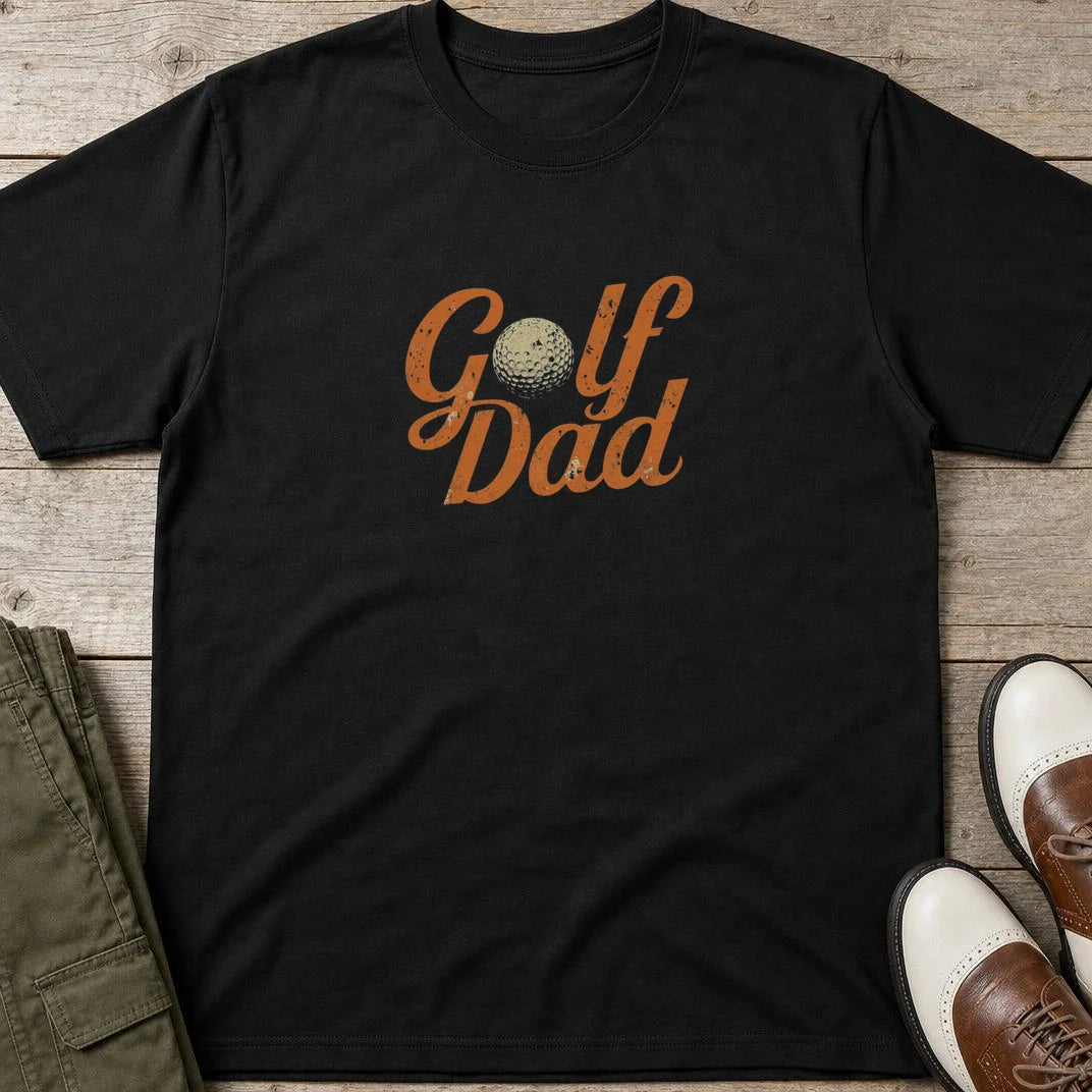Golf Dad II T-Shirt in Black lying on a plain floor. T-shirt is a unisex cut and 100 per cent cotton.