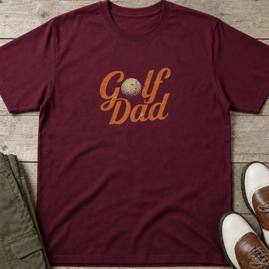Golf Dad II T-Shirt in Maroon lying on a plain floor. T-shirt is a unisex cut and 100 per cent cotton.