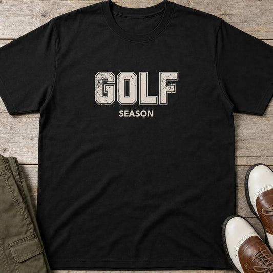 Golf Season T-Shirt in Black lying on a plain floor. T-shirt is a unisex cut and 100 per cent cotton.