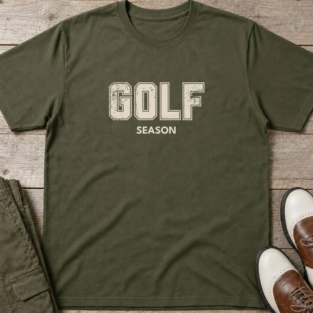 Golf Season T-Shirt in Military Green lying on a plain floor. T-shirt is a unisex cut and 100 per cent cotton.