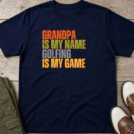 Grandpa Golfing T-Shirt in Navy lying on a plain floor. T-shirt is a unisex cut and 100 per cent cotton.
