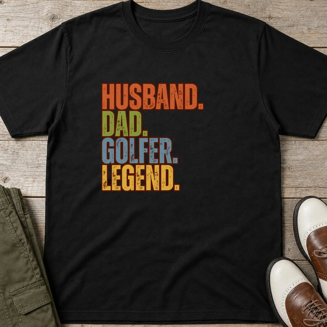 Husband Dad T-Shirt in Black lying on a plain floor. T-shirt is a unisex cut and 100 per cent cotton.
