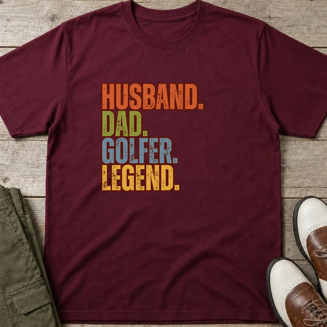 Husband Dad T-Shirt in Maroon lying on a plain floor. T-shirt is a unisex cut and 100 per cent cotton.