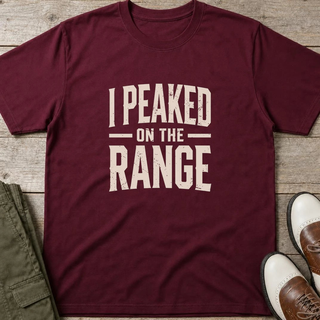 I Peaked T-Shirt in Maroon lying on a plain floor. T-shirt is a unisex cut and 100 per cent cotton.