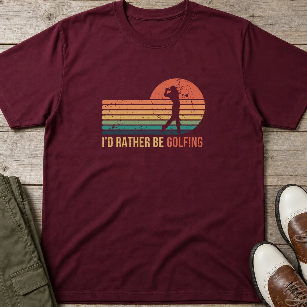 Rather Be Golfing T-Shirt in Maroon lying on a plain floor. T-shirt is a unisex cut and 100 per cent cotton.