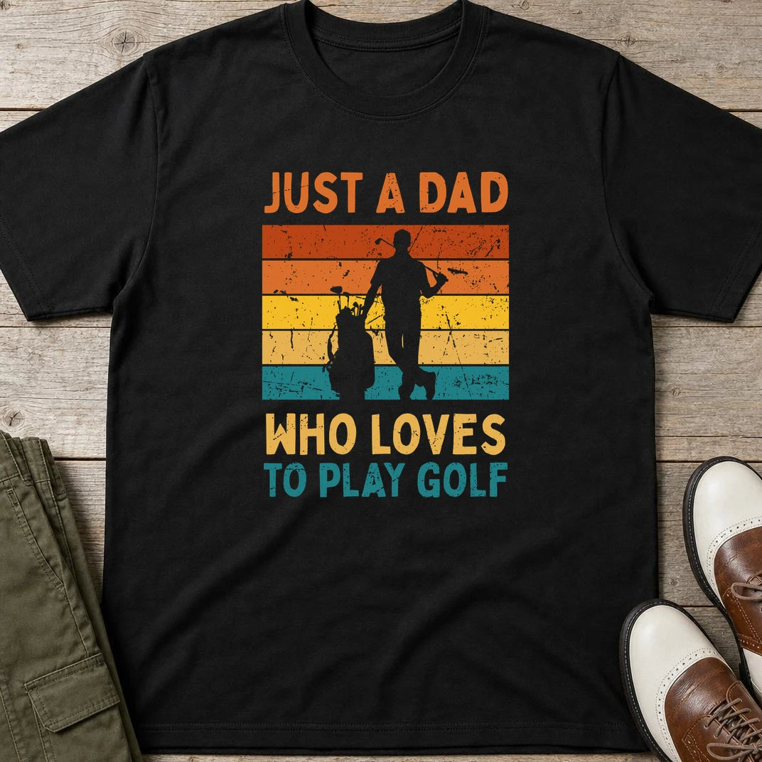 Just A Dad T-Shirt in Black lying on a plain floor. T-shirt is a unisex cut and 100 per cent cotton.