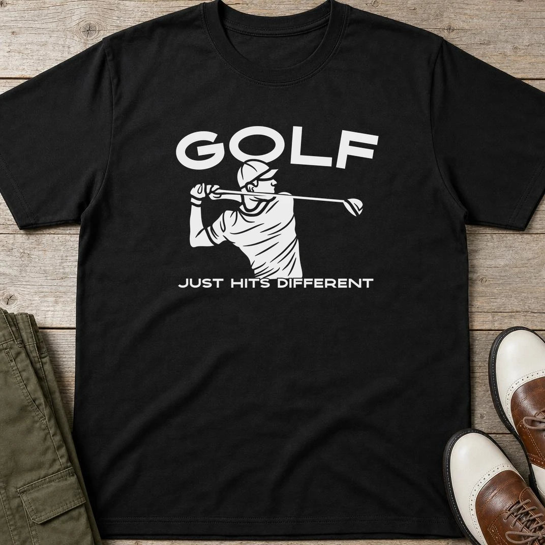 Hits Different T-Shirt in Black lying on a plain floor. T-shirt is a unisex cut and 100 per cent cotton.
