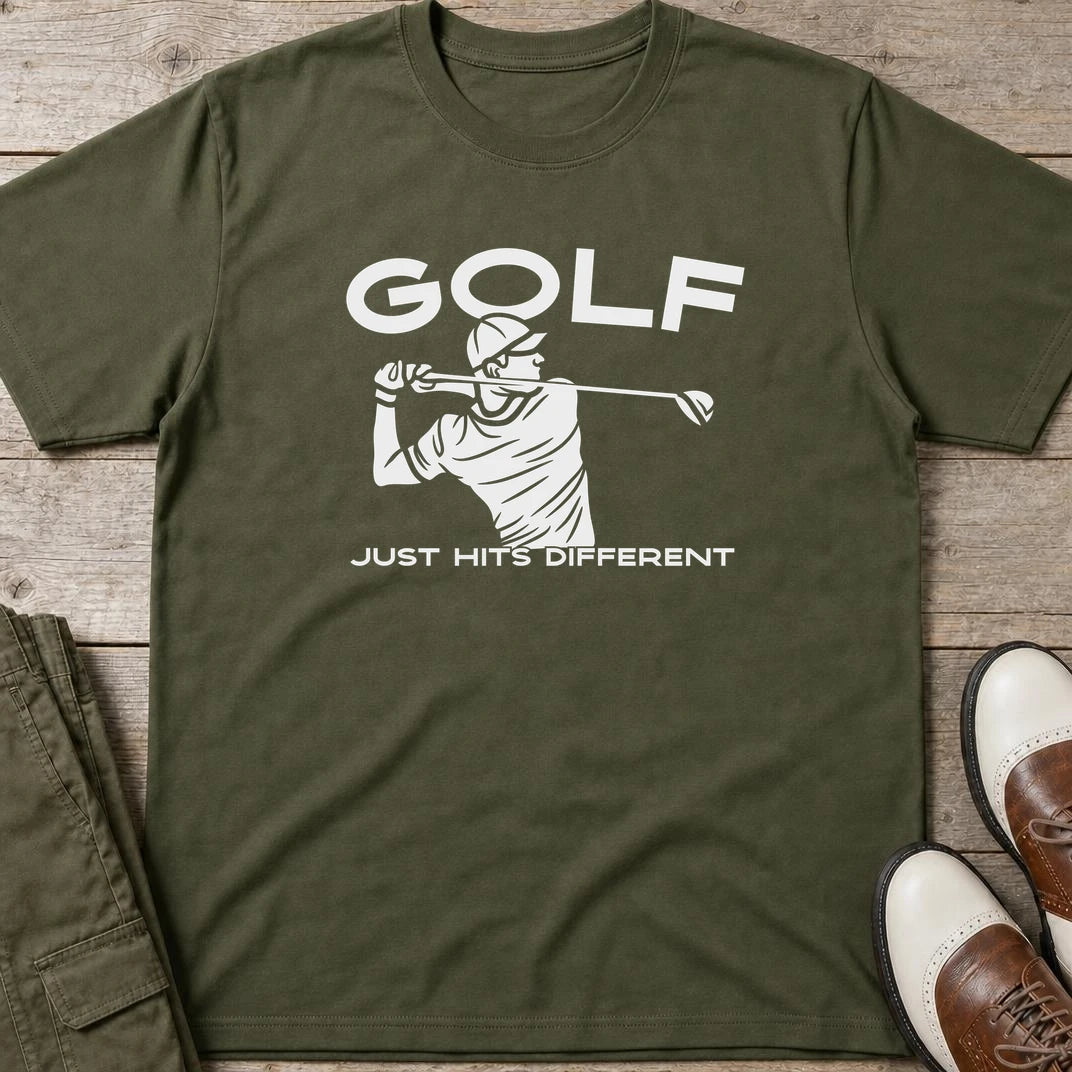 Hits Different T-Shirt in Military Green lying on a plain floor. T-shirt is a unisex cut and 100 per cent cotton.