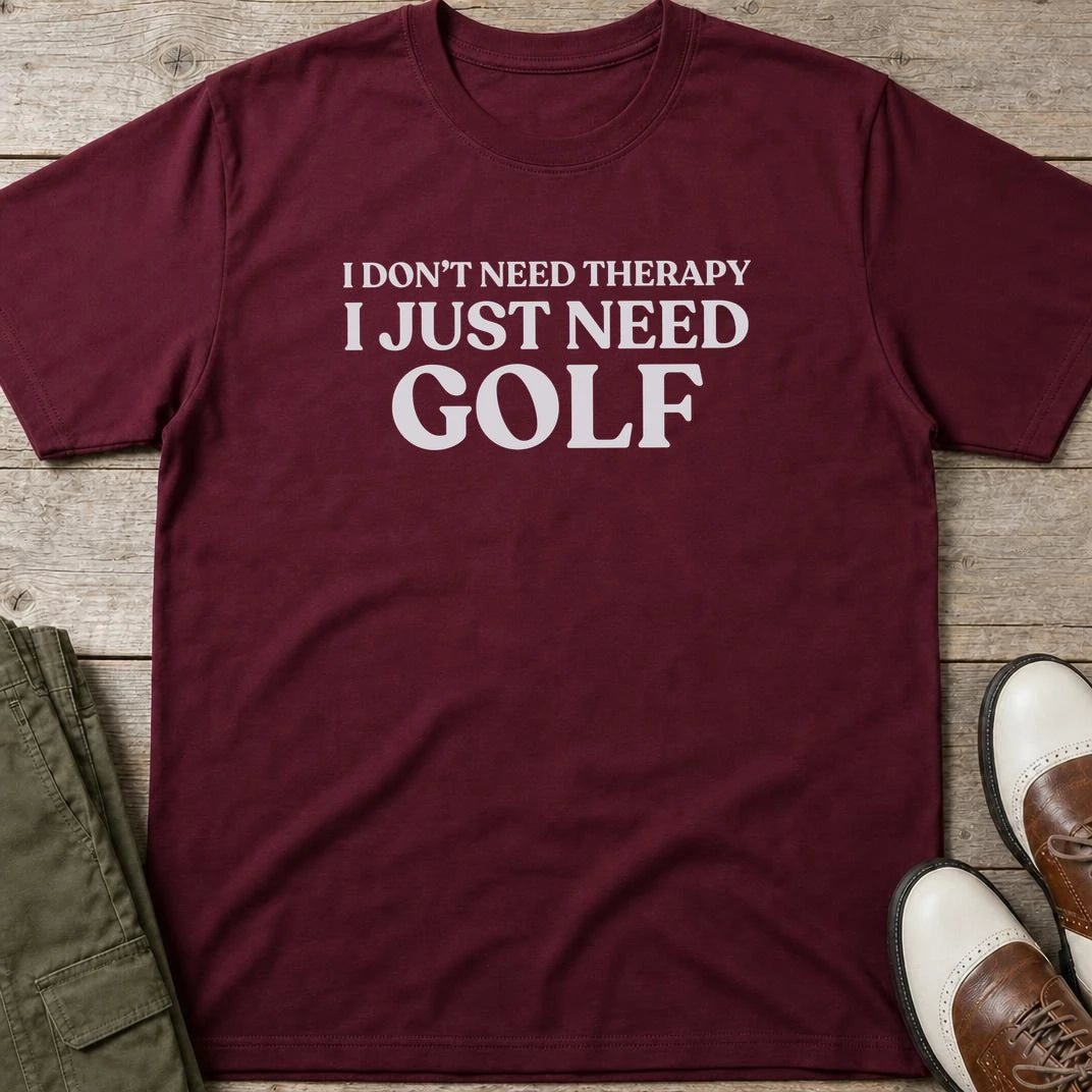 Just Need Golf T-Shirt in Maroon lying on a plain floor. T-shirt is a unisex cut and 100 per cent cotton.