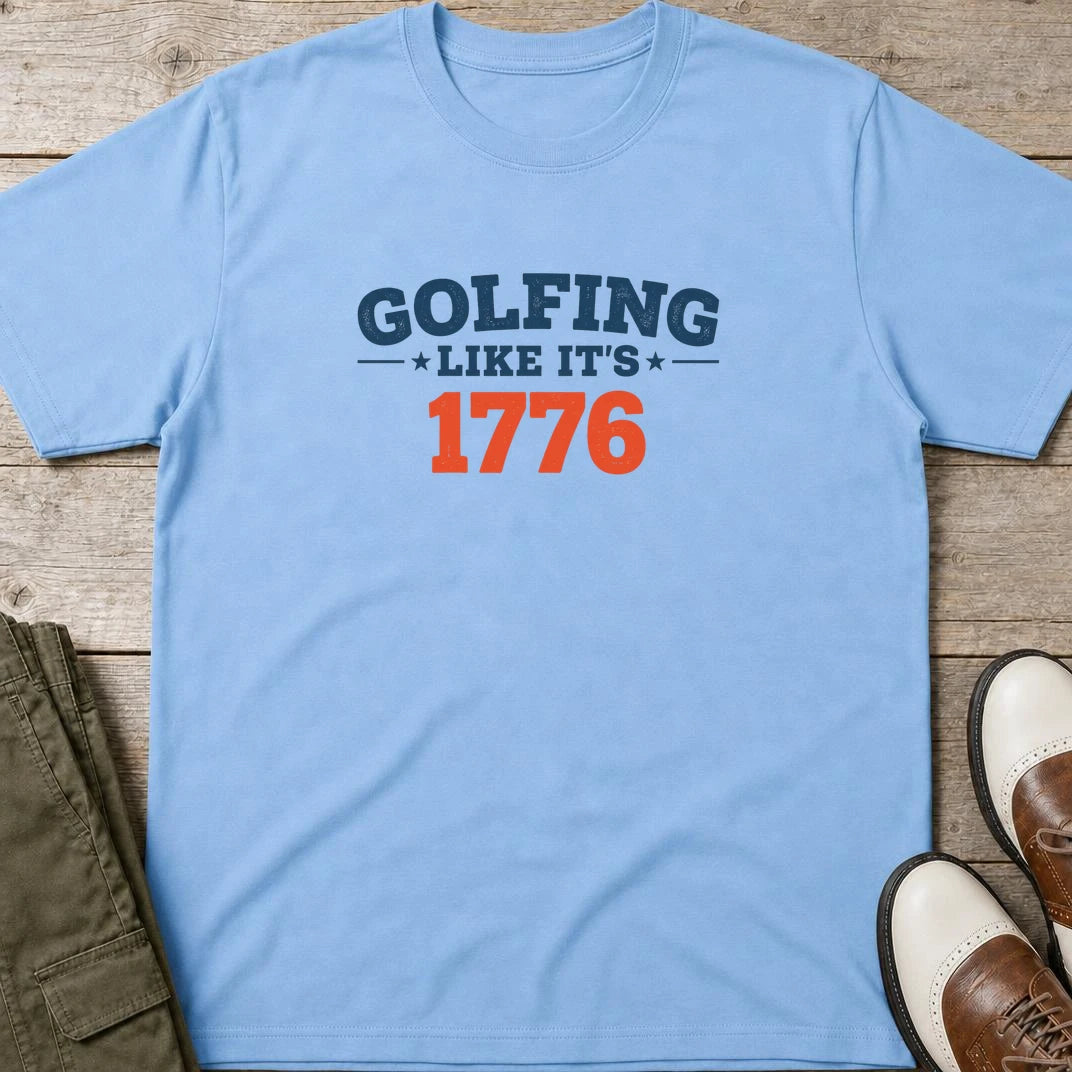 Golfing 1776 T-Shirt in Light Blue lying on a plain floor. T-shirt is a unisex cut and 100 per cent cotton.