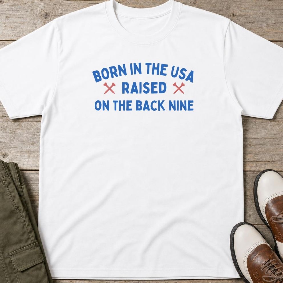 Born In The USA T-Shirt in lying on a plain floor. T-shirt is a unisex cut and 100 per cent cotton.