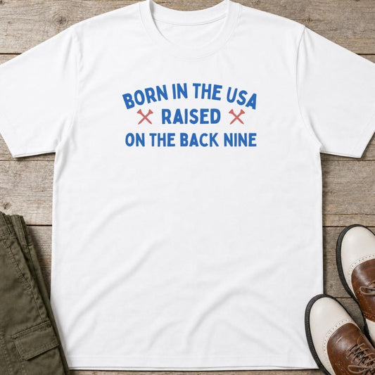 Born In The USA T-Shirt in lying on a plain floor. T-shirt is a unisex cut and 100 per cent cotton.