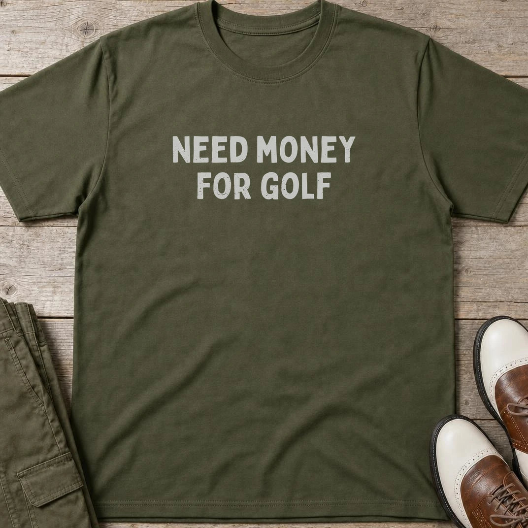 Need Money T-Shirt in Military Green lying on a plain floor. T-shirt is a unisex cut and 100 per cent cotton.