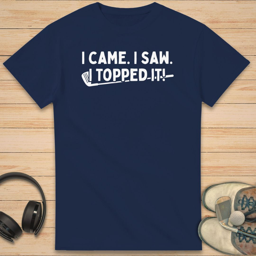Topped It T-Shirt in Navy on a light wooden floor lying next to headphones and golf shoes.