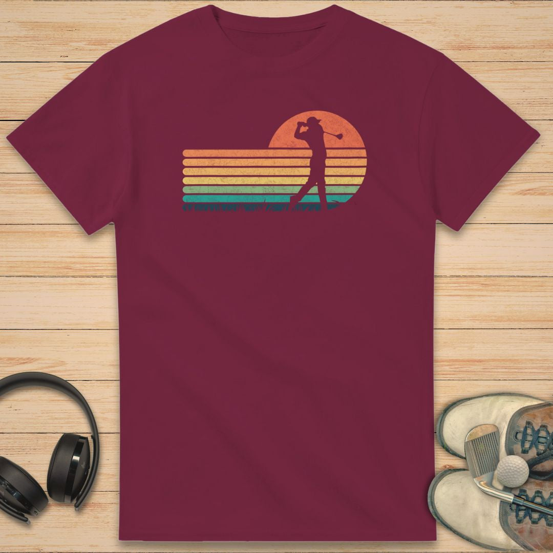 Vintage Golfer T-Shirt in Maroon on a light wooden floor lying next to headphones and golf shoes.
