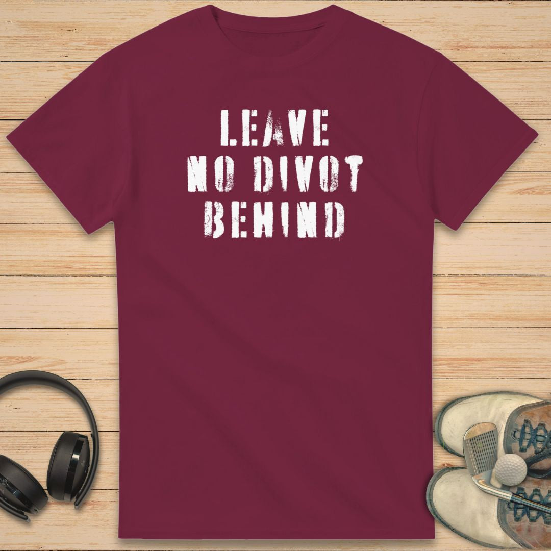 No Divot T-Shirt in Maroon on a light wooden floor lying next to headphones and golf shoes.