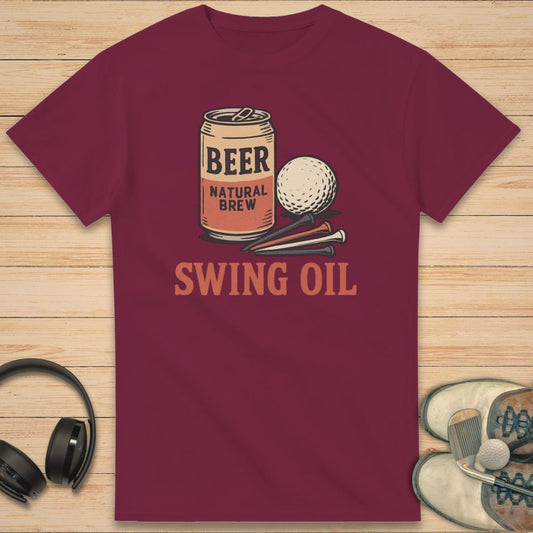 Swing Oil T-Shirt in Maroon on a light wooden floor lying next to headphones and golf shoes.