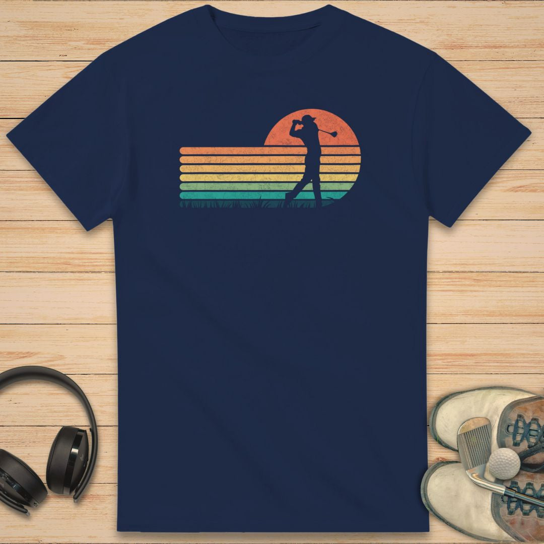 Vintage Golfer T-Shirt in Navy on a light wooden floor lying next to headphones and golf shoes.