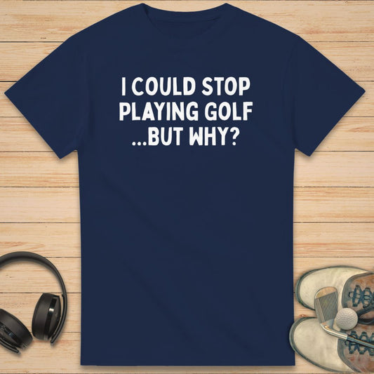 But Why? T-Shirt in Navy on a light wooden floor lying next to headphones and golf shoes.