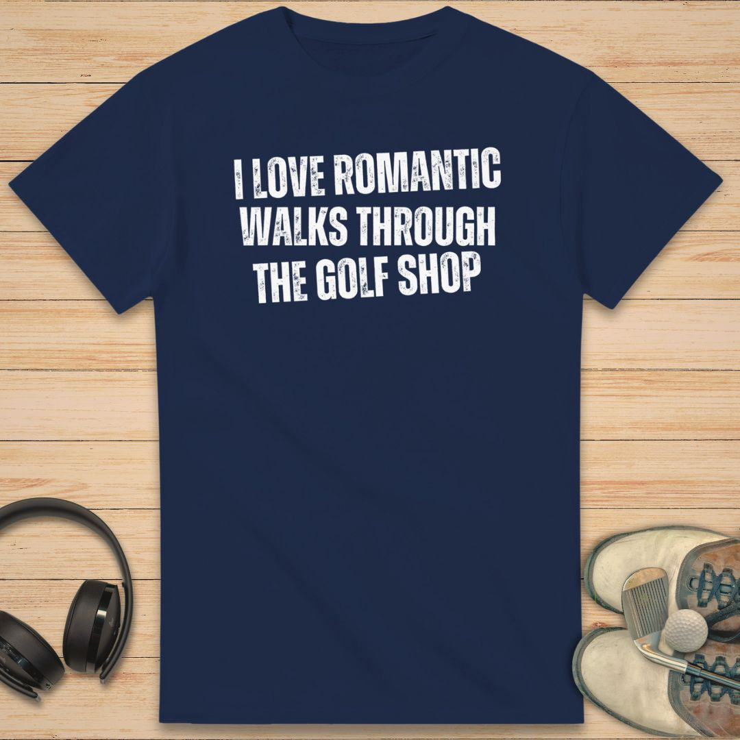 Romantic Walks T-Shirt in Navy on a light wooden floor lying next to headphones and golf shoes.