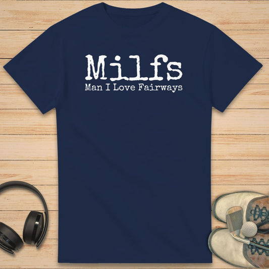Milfs T-Shirt in Navy on a light wooden floor lying next to headphones and golf shoes.