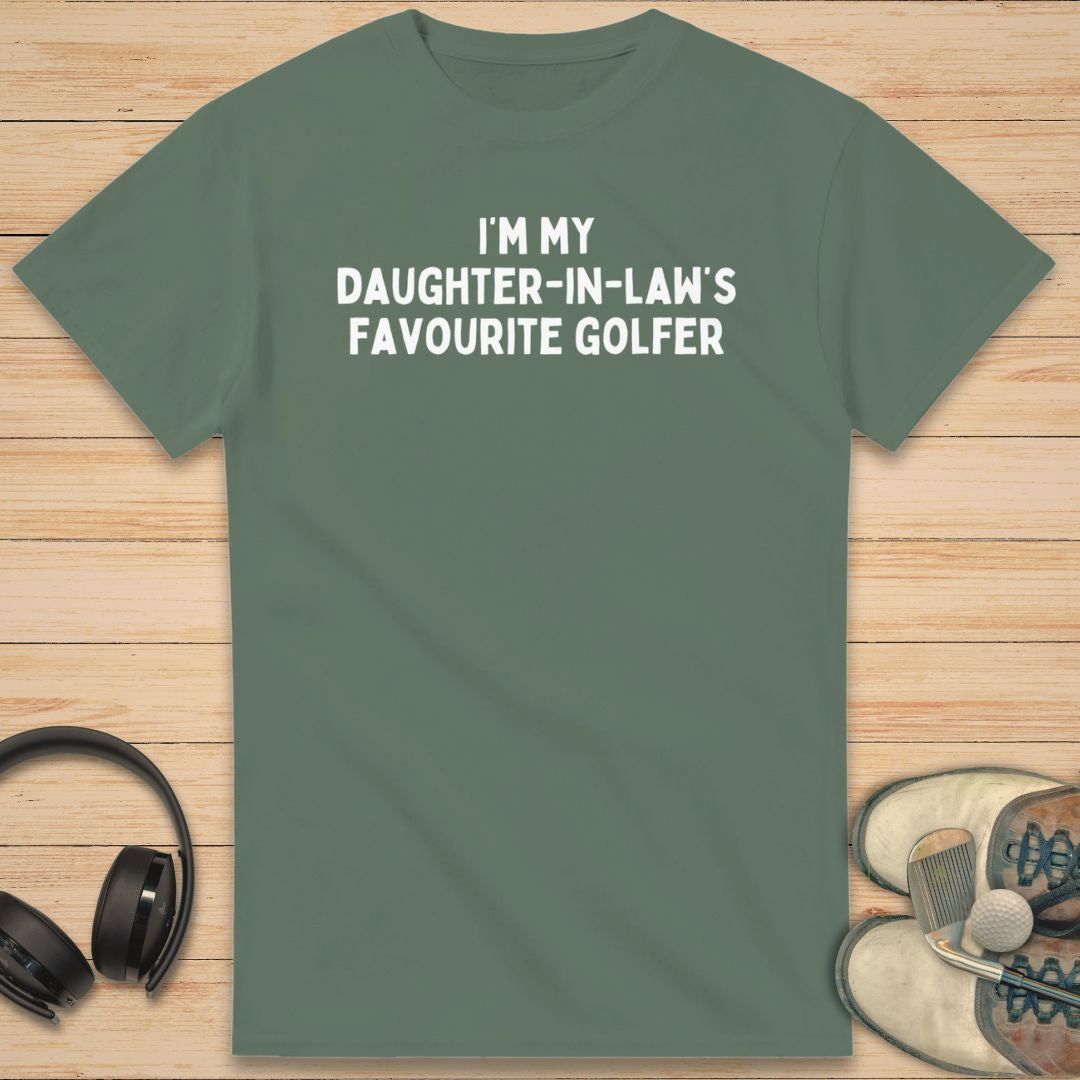 Daughter-In-Law T-Shirt in Military Green on a light wooden floor lying next to headphones and golf shoes.