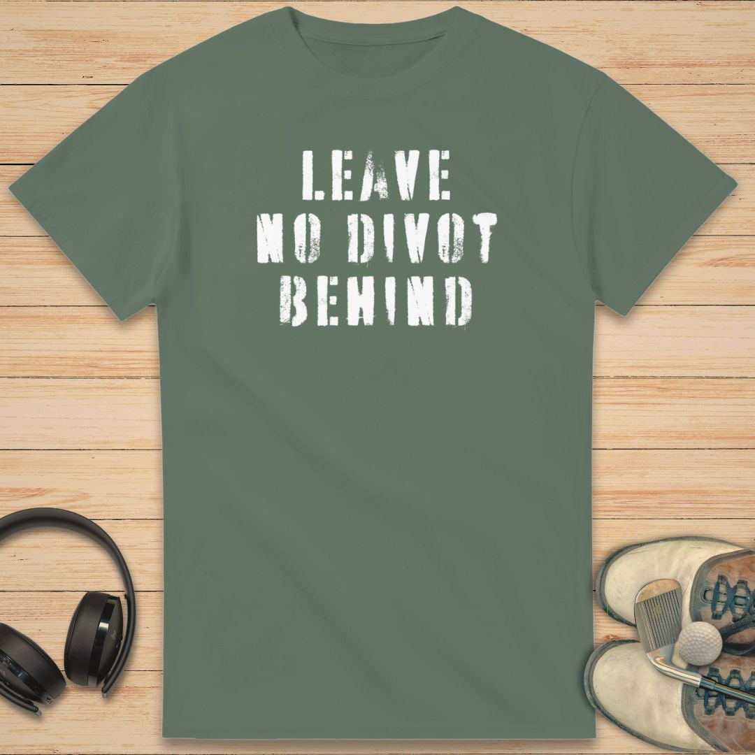 No Divot T-Shirt in Military Green on a light wooden floor lying next to headphones and golf shoes.