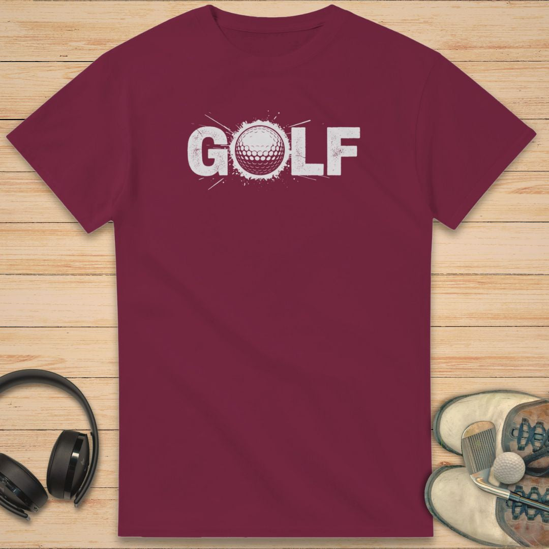 Golf Crash T-Shirt in Maroon on a light wooden floor lying next to headphones and golf shoes.