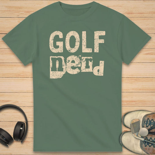 Golf Nerd T-Shirt in Military Green on a light wooden floor lying next to headphones and golf shoes.