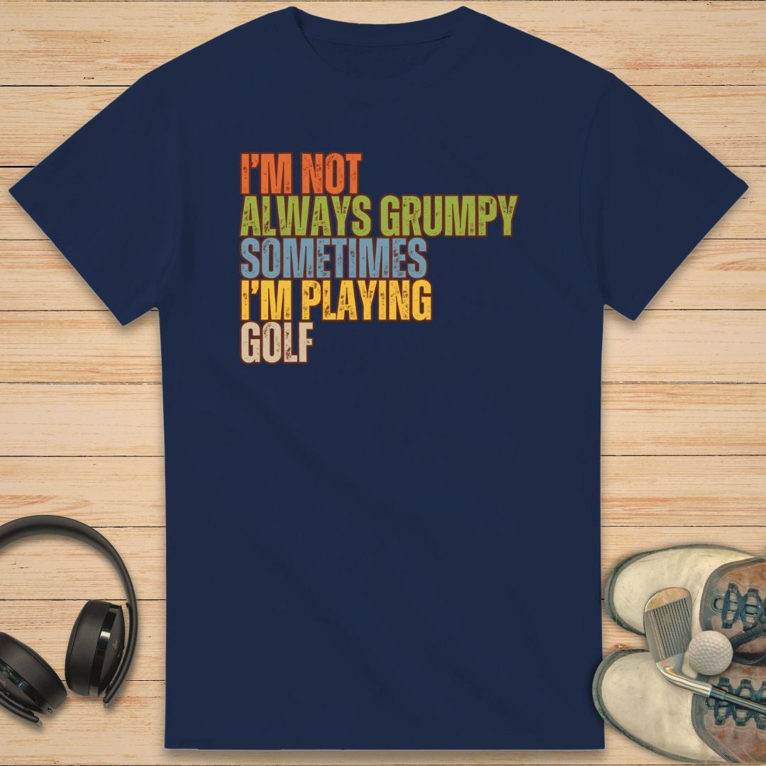 Grumpy Classic T-Shirt in Navy on a light wooden floor lying next to headphones and golf shoes.