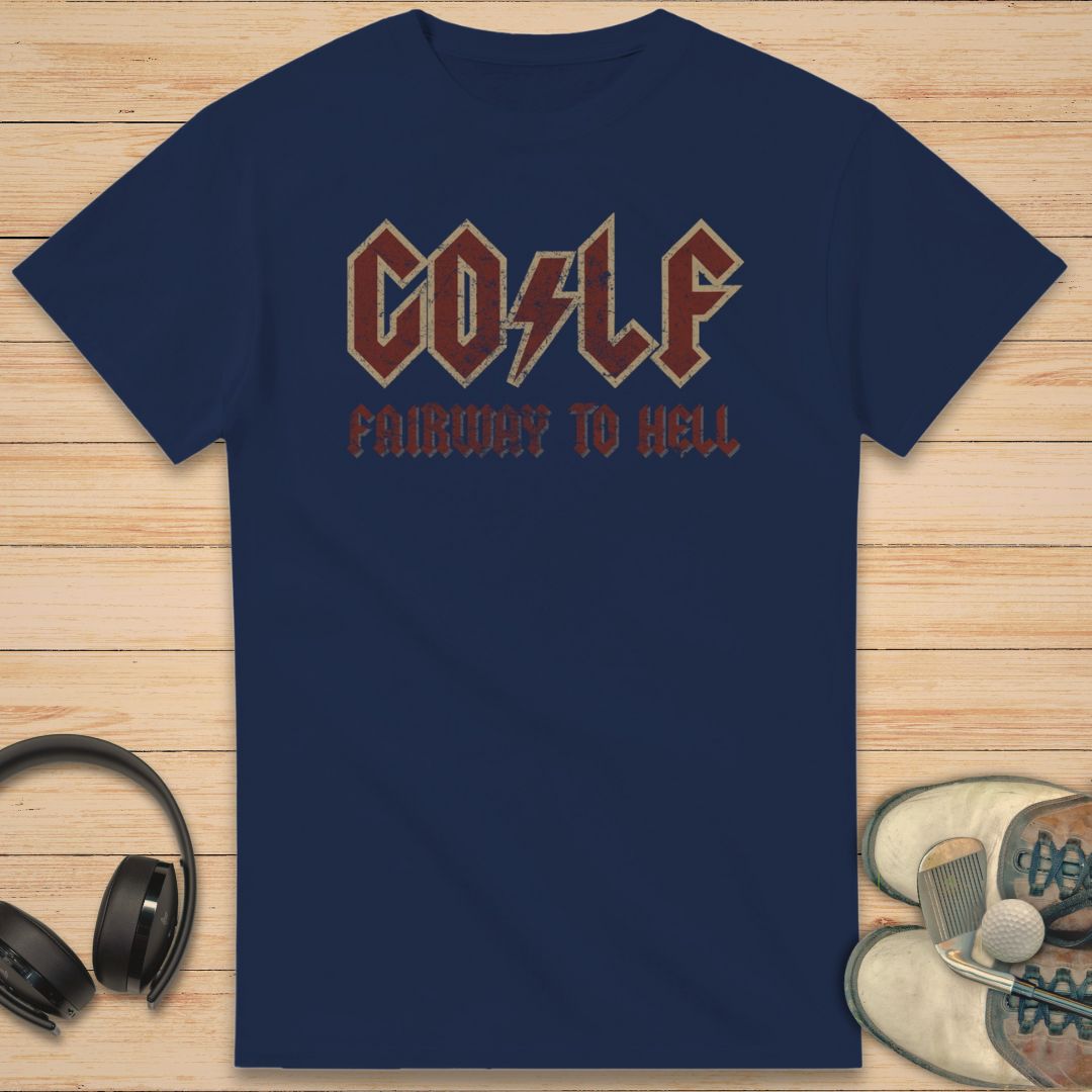 Fairway To Hell T-Shirt in Navy on a light wooden floor lying next to headphones and golf shoes.