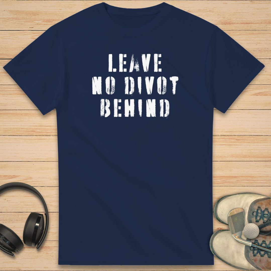 No Divot T-Shirt in Navy on a light wooden floor lying next to headphones and golf shoes.