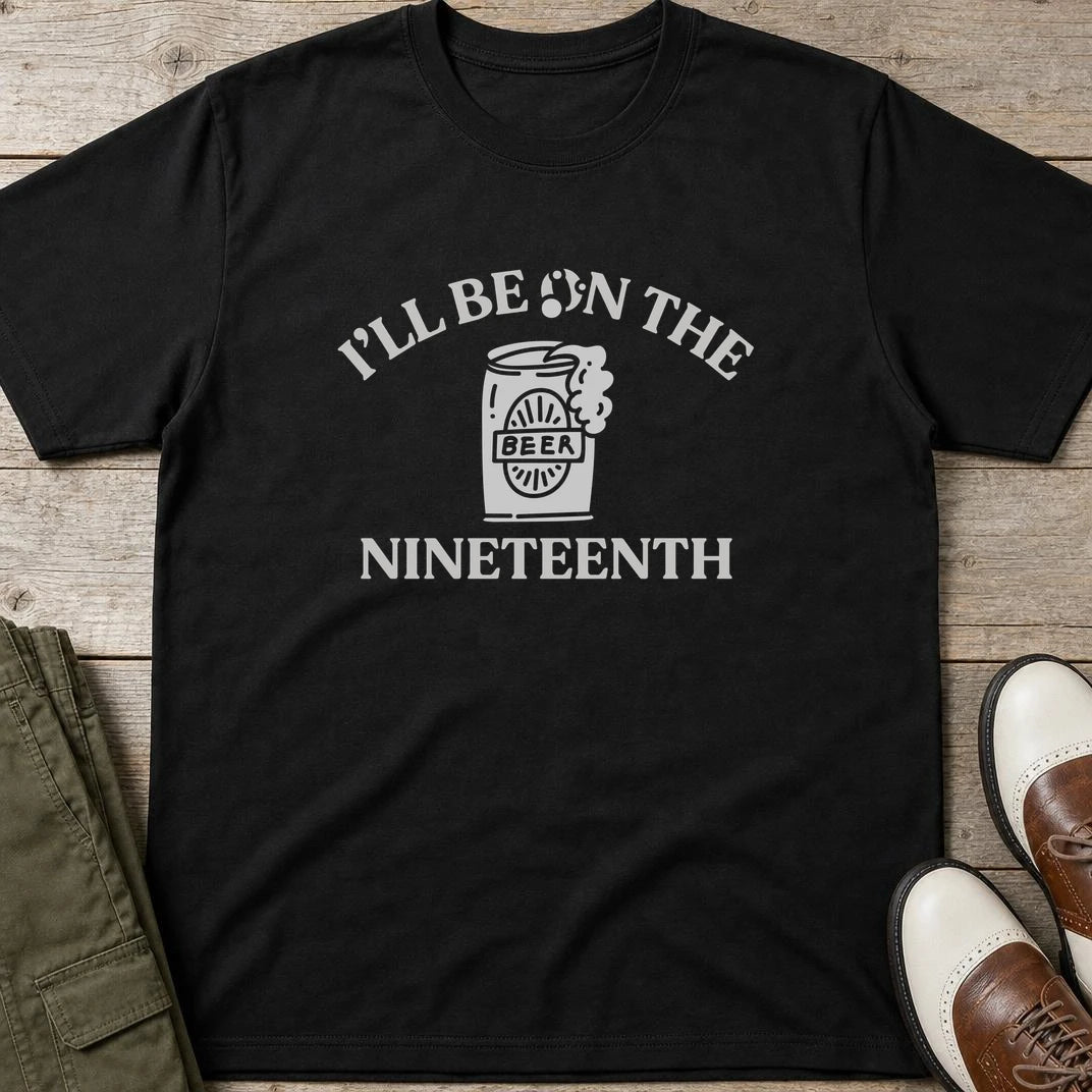 The Nineteenth T-Shirt in Black lying on a plain floor. T-shirt is a unisex cut and 100 per cent cotton.
