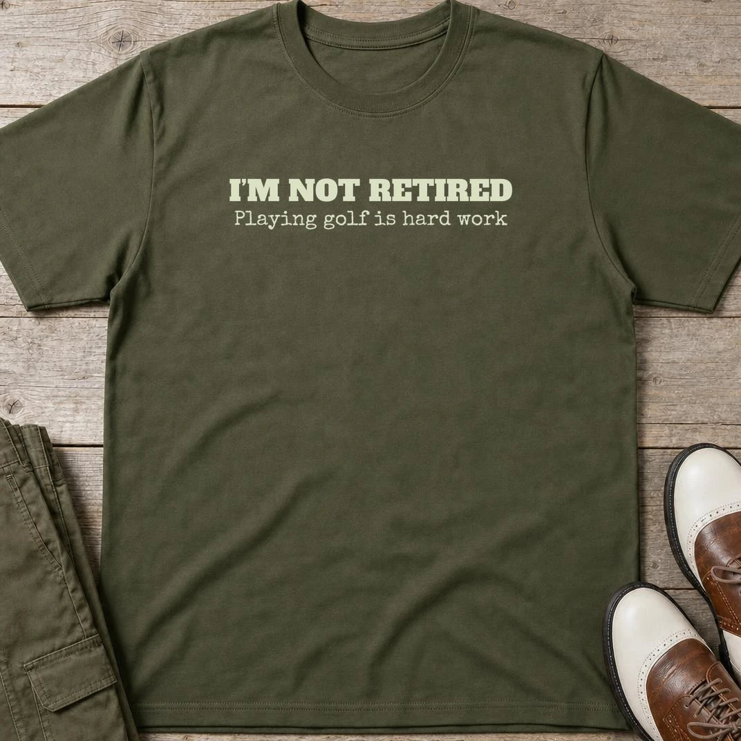 Not Retired T-Shirt in Military Green lying on a plain floor. T-shirt is a unisex cut and 100 per cent cotton.