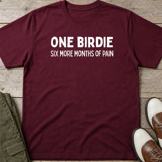 One Birdie T-Shirt in Maroon lying on a plain floor. T-shirt is a unisex cut and 100 per cent cotton.