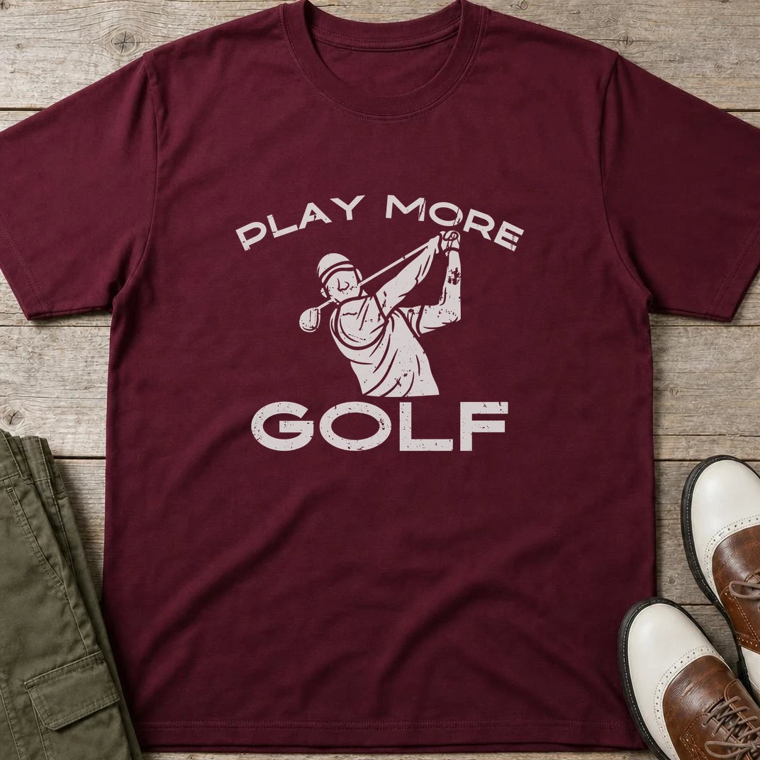Play More Golf T-Shirt in Maroon lying on a plain floor. T-shirt is a unisex cut and 100 per cent cotton.