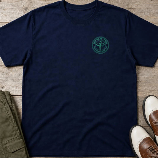 Too Many Clubs Pocket T-Shirt in Navy lying on a plain floor. T-shirt is a unisex cut and 100 per cent cotton.
