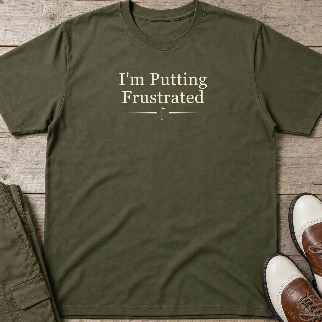 Putting Frustrated T-Shirt in Military Green lying on a plain floor. T-shirt is a unisex cut and 100 per cent cotton.