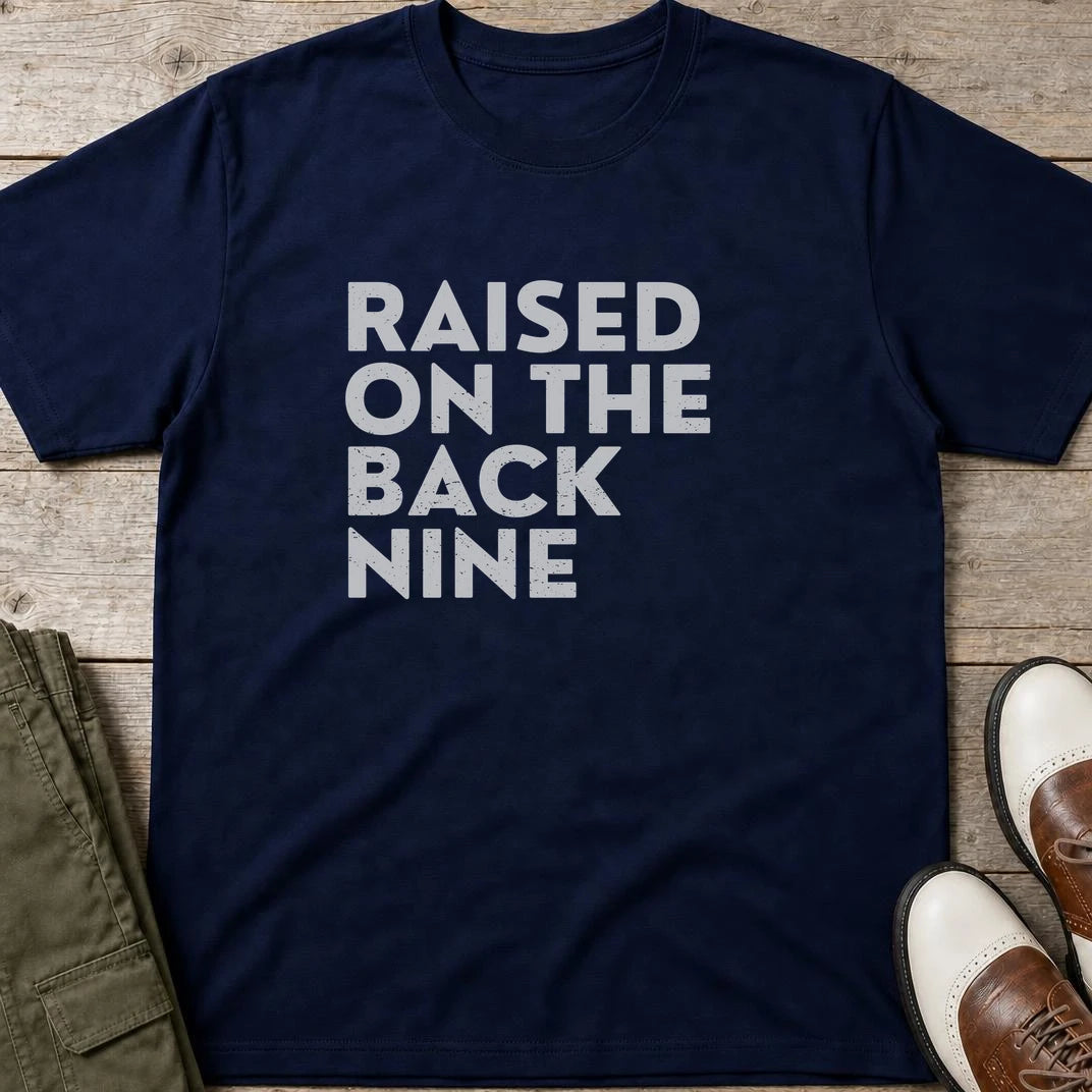 Raised On T-Shirt in Navy lying on a plain floor. T-shirt is a unisex cut and 100 per cent cotton.