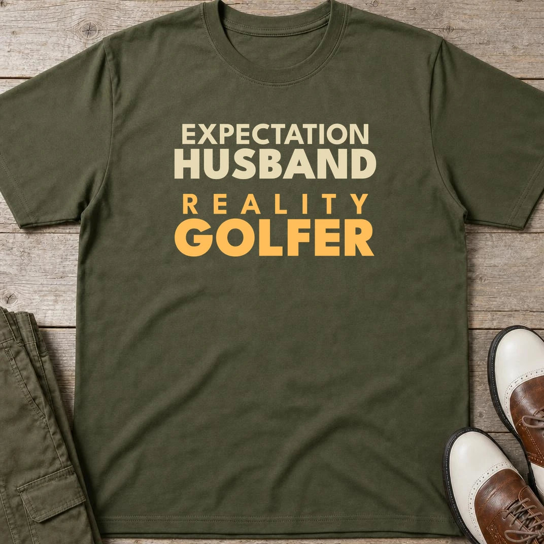Reality Golfer T-Shirt in Military Green lying on a plain floor. T-shirt is a unisex cut and 100 per cent cotton.