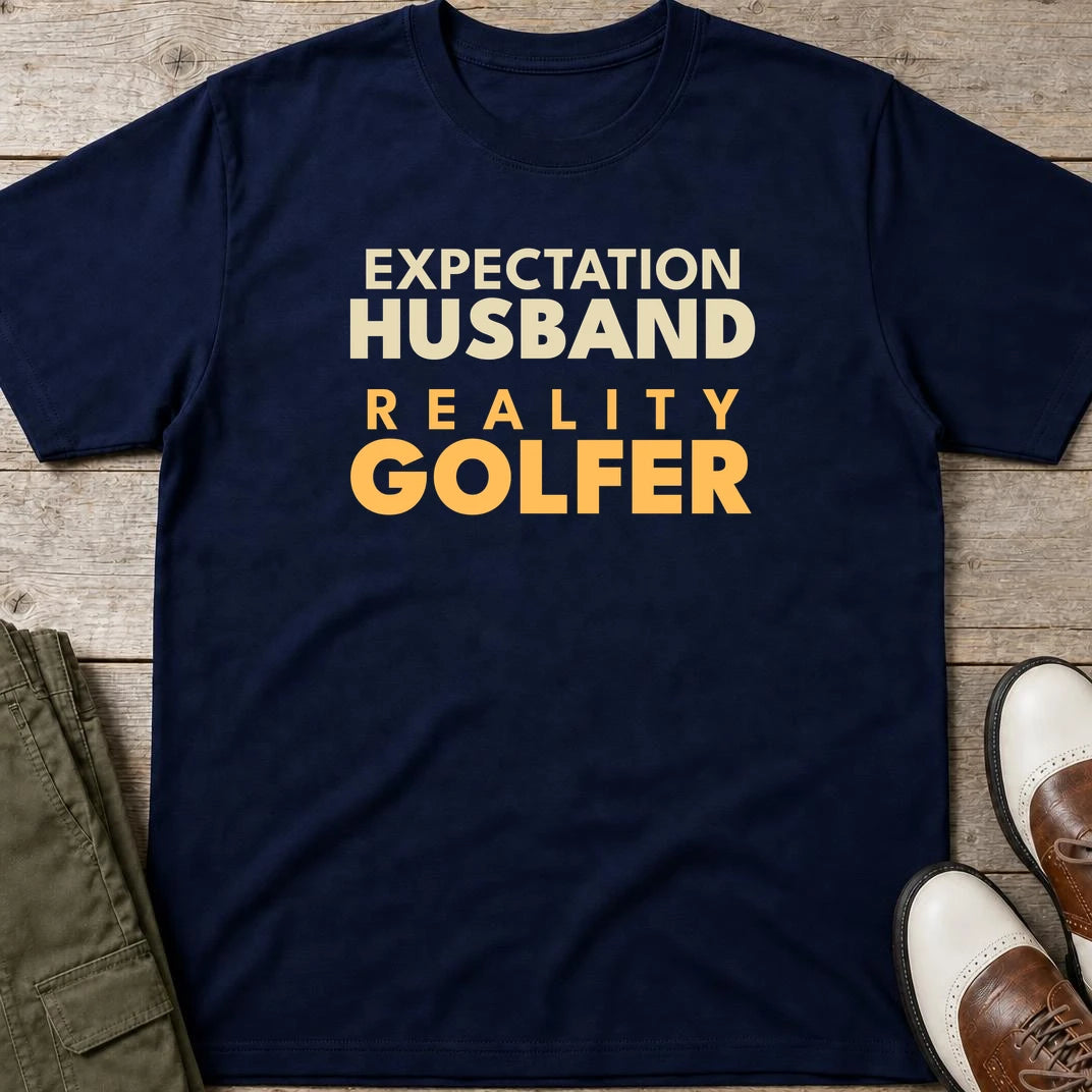 Reality Golfer T-Shirt in Navy lying on a plain floor. T-shirt is a unisex cut and 100 per cent cotton.
