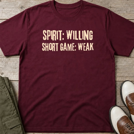 Spirit Willing T-Shirt in Maroon lying on a plain floor. T-shirt is a unisex cut and 100 per cent cotton.