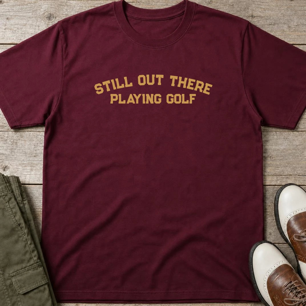 Still Out There T-Shirt in Maroon lying on a plain floor. T-shirt is a unisex cut and 100 per cent cotton.