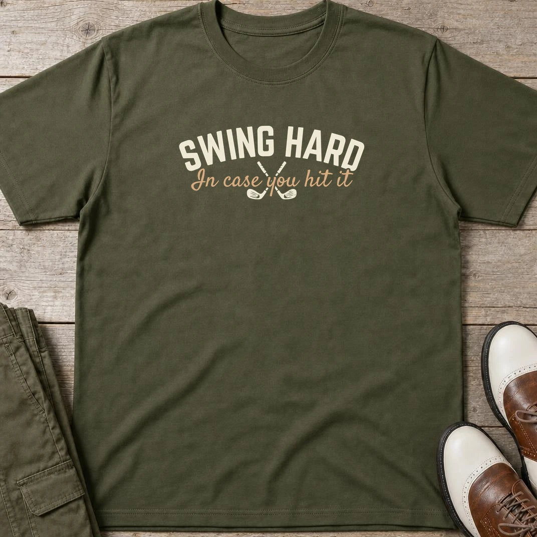 Swing Hard Hit It T-Shirt in Military Green lying on a plain floor. T-shirt is a unisex cut and 100 per cent cotton.