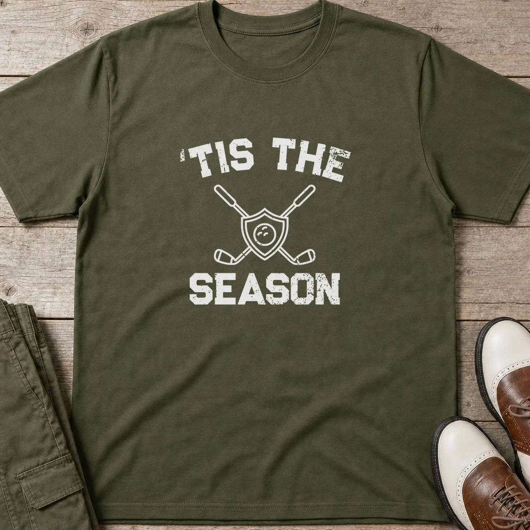 'Tis The Season T-Shirt in Military Green lying on a plain floor. T-shirt is a unisex cut and 100 per cent cotton.