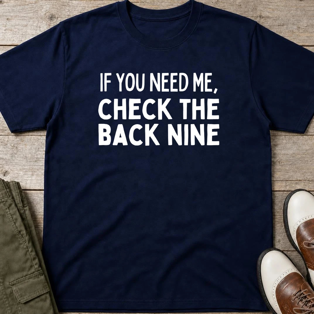The Back Nine T-Shirt in Navy lying on a plain floor. T-shirt is a unisex cut and 100 per cent cotton.