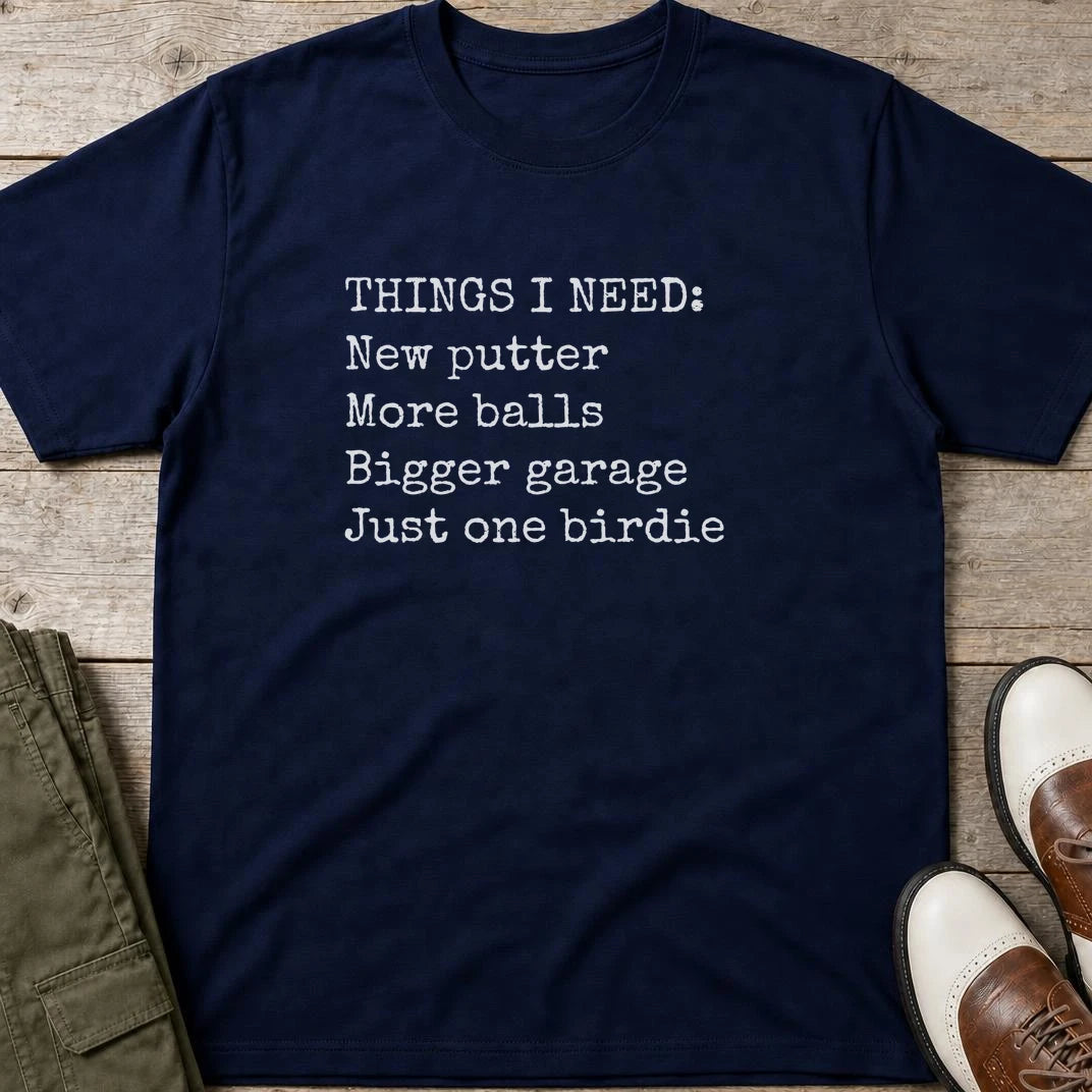 Things I Need T-Shirt in Navy lying on a plain floor. T-shirt is a unisex cut and 100 per cent cotton.